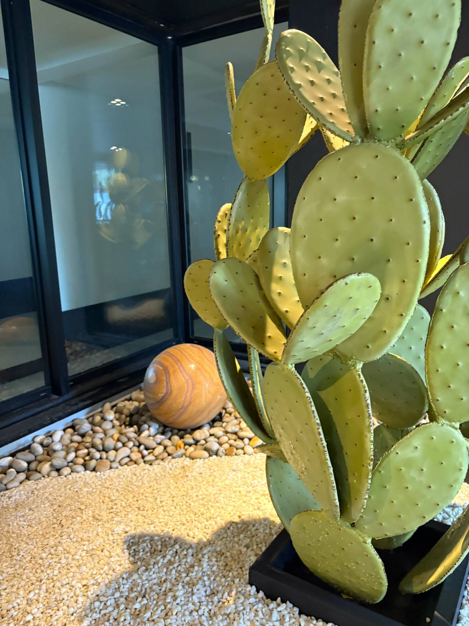 Vue rapprochée d’un cactus en métal dans un patio paysager moderne à Bordeaux