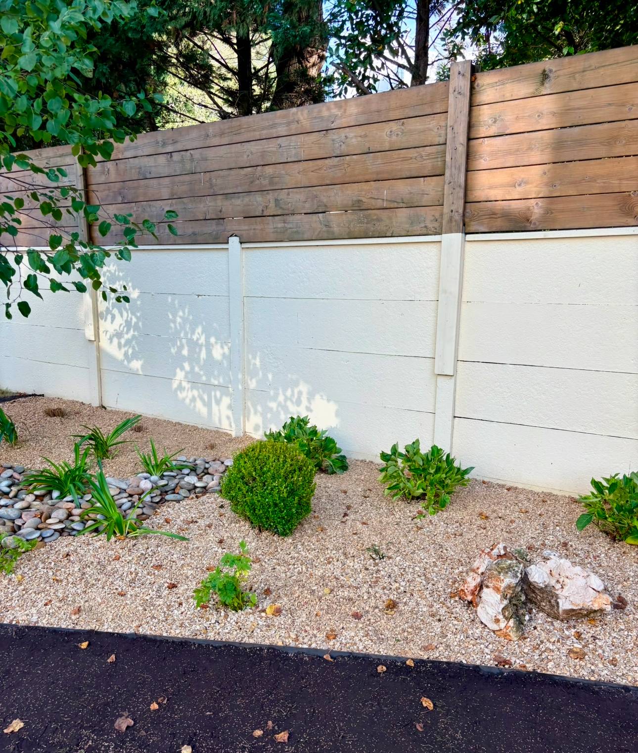 Massif minéral avec cailloux plats ocre et galets de rivière au Bouscat