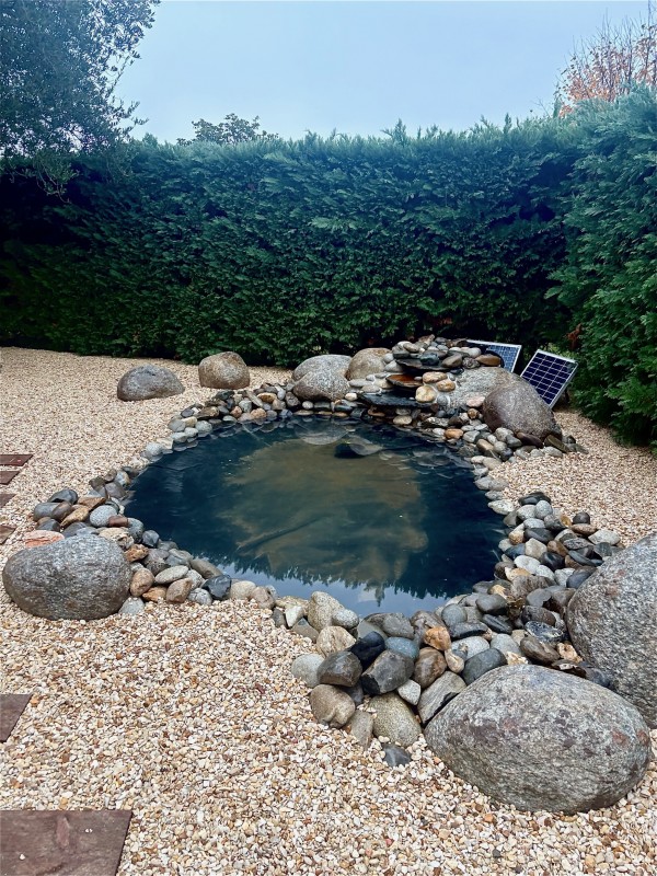 Création d’un bassin paysager avec cascade à Libourne : bassin à poissons, rochers et galets de rivière, pompe solaire et aménagement paysager complet sur mesure